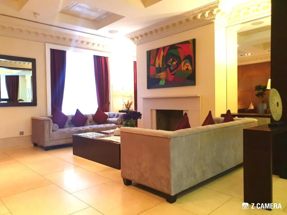 a living room with a couch and a fireplace at The Park City Grand Plaza Kensington Hotel in London