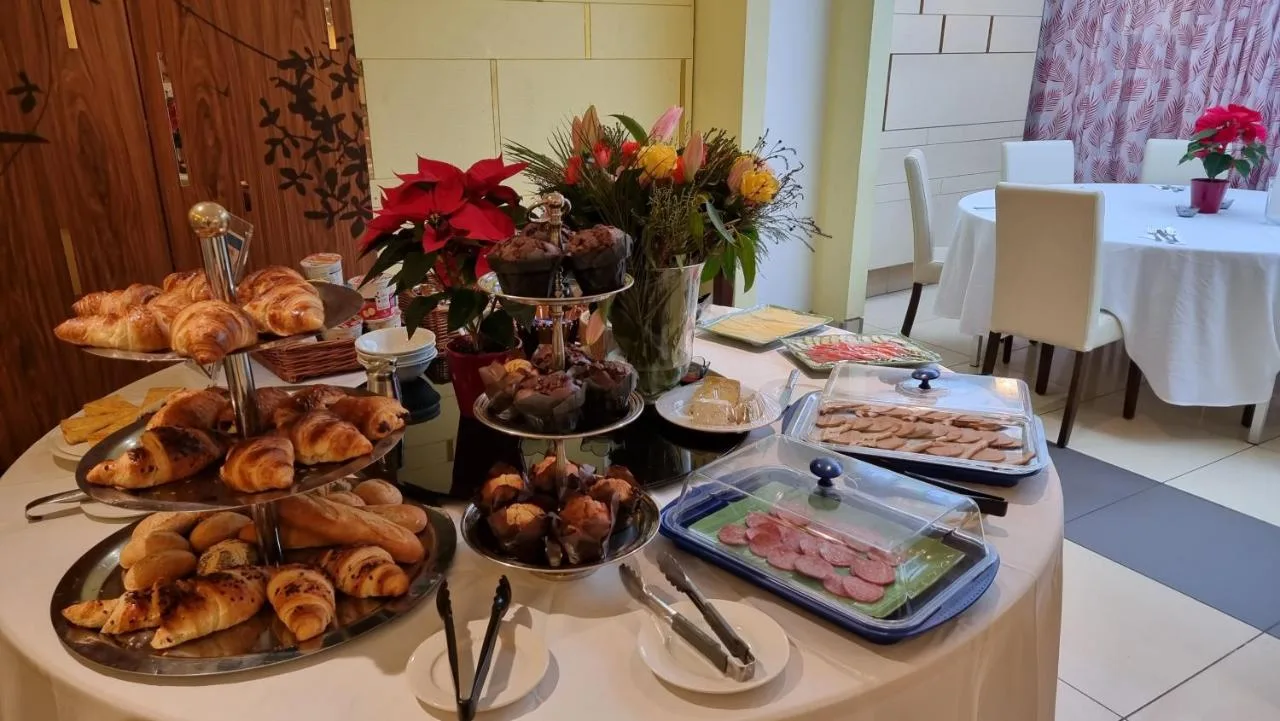 a table with different types of pastries and other foods at The Park City Grand Plaza Kensington Hotel in London